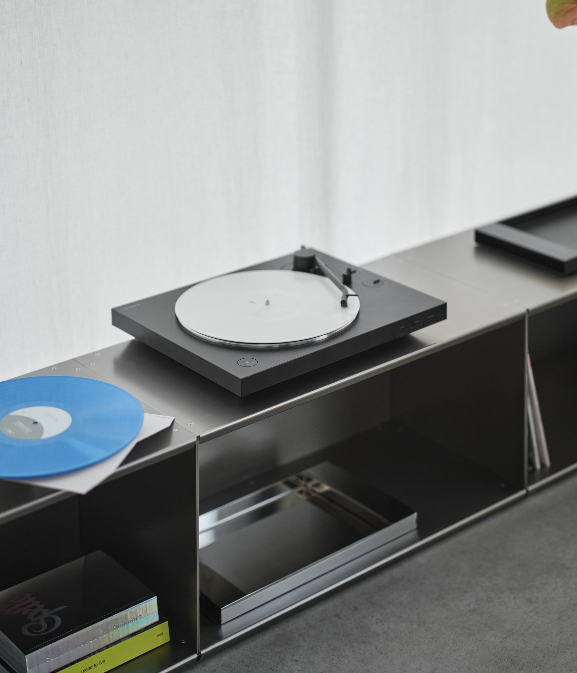 Turntable on a modern entertainment console built with M85 aluminum modular shelving system with a white background