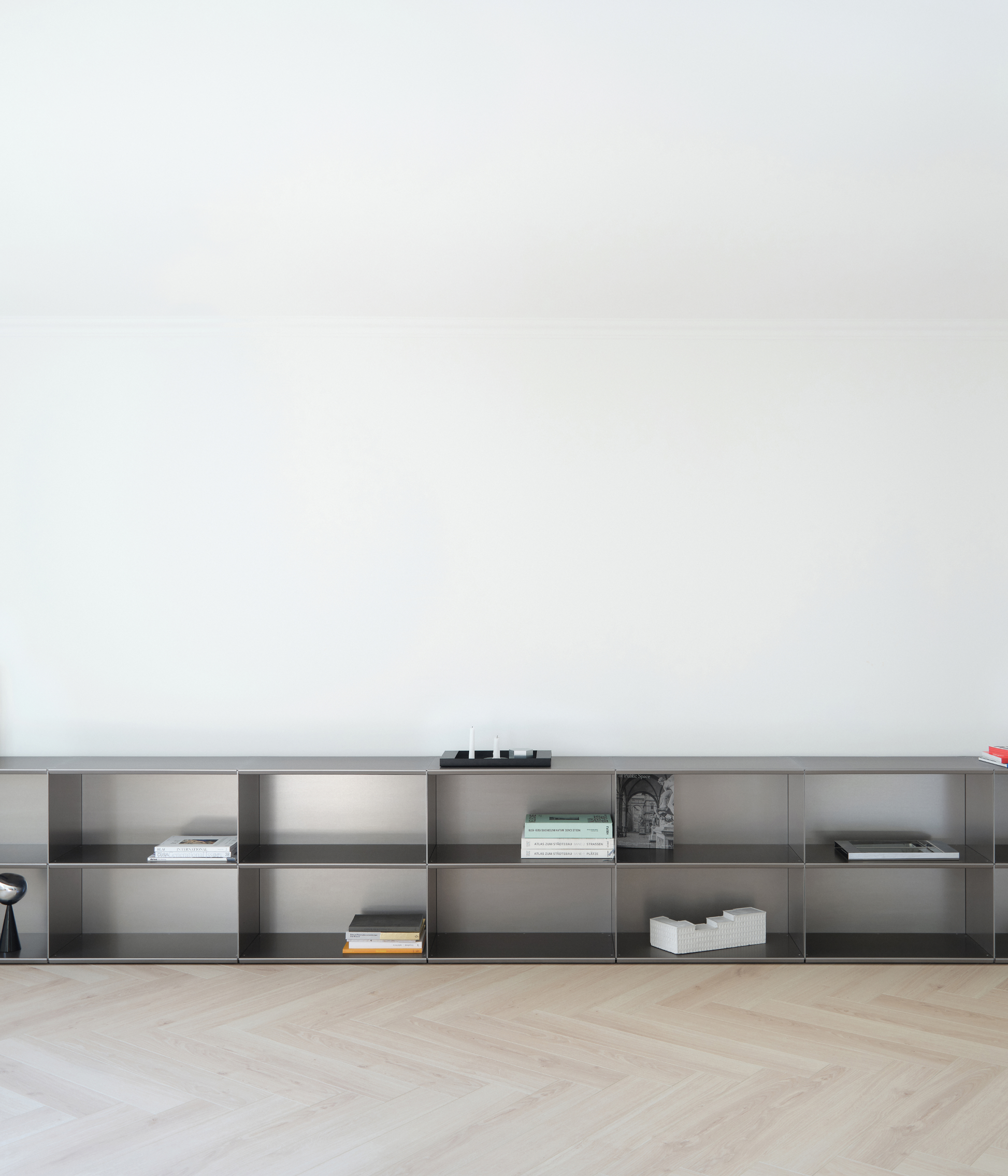 Modern modular M85 aluminum shelf with minimal decor against a white wall