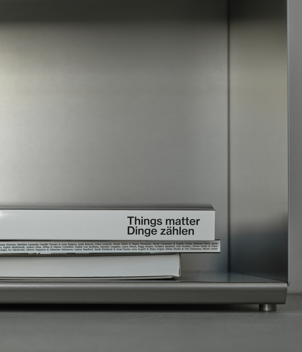 M85 gunmetal aluminum bookshelf with a book titled 'Things matter Dinge zählen' 