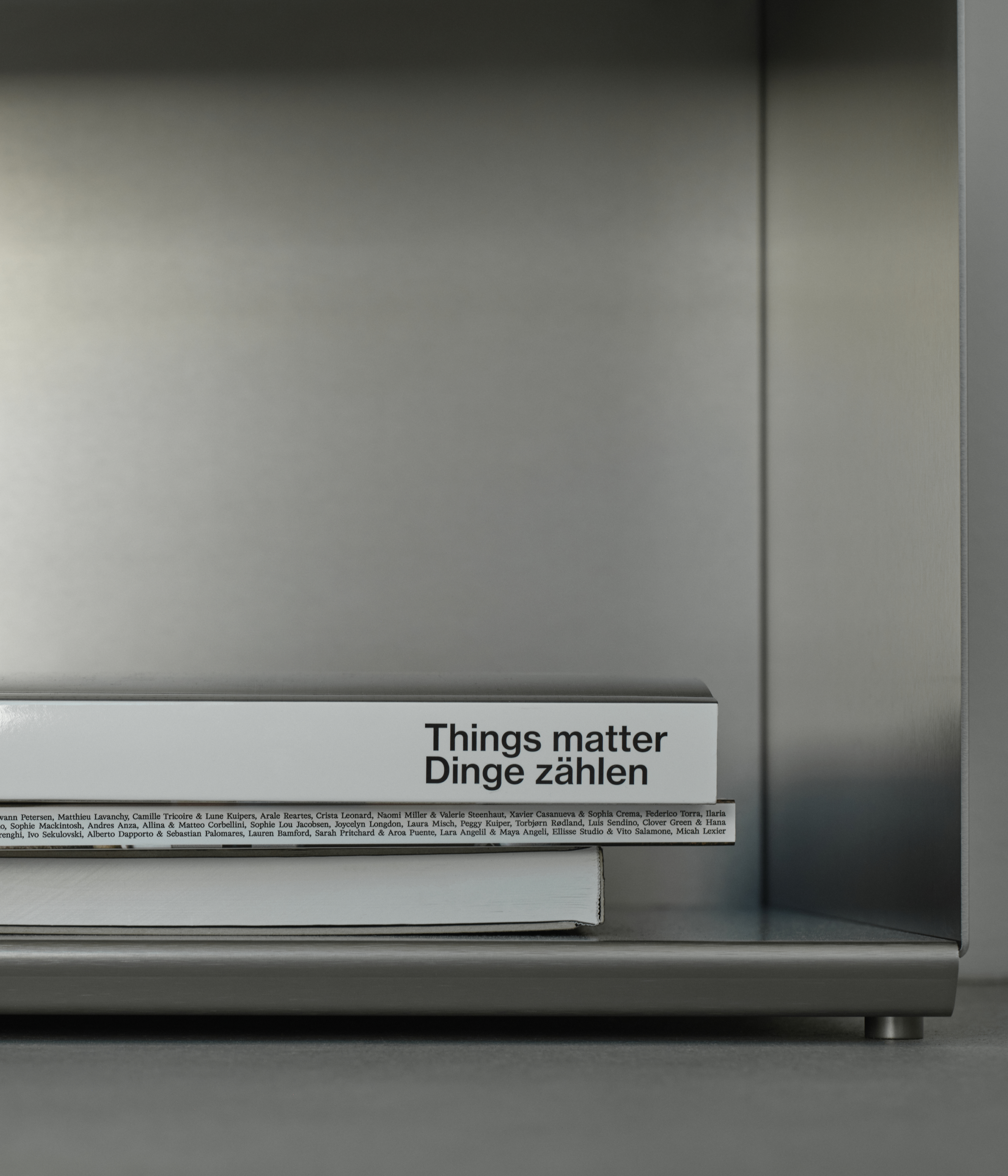 M85 gunmetal aluminum bookshelf with a book titled 'Things matter Dinge zählen' 