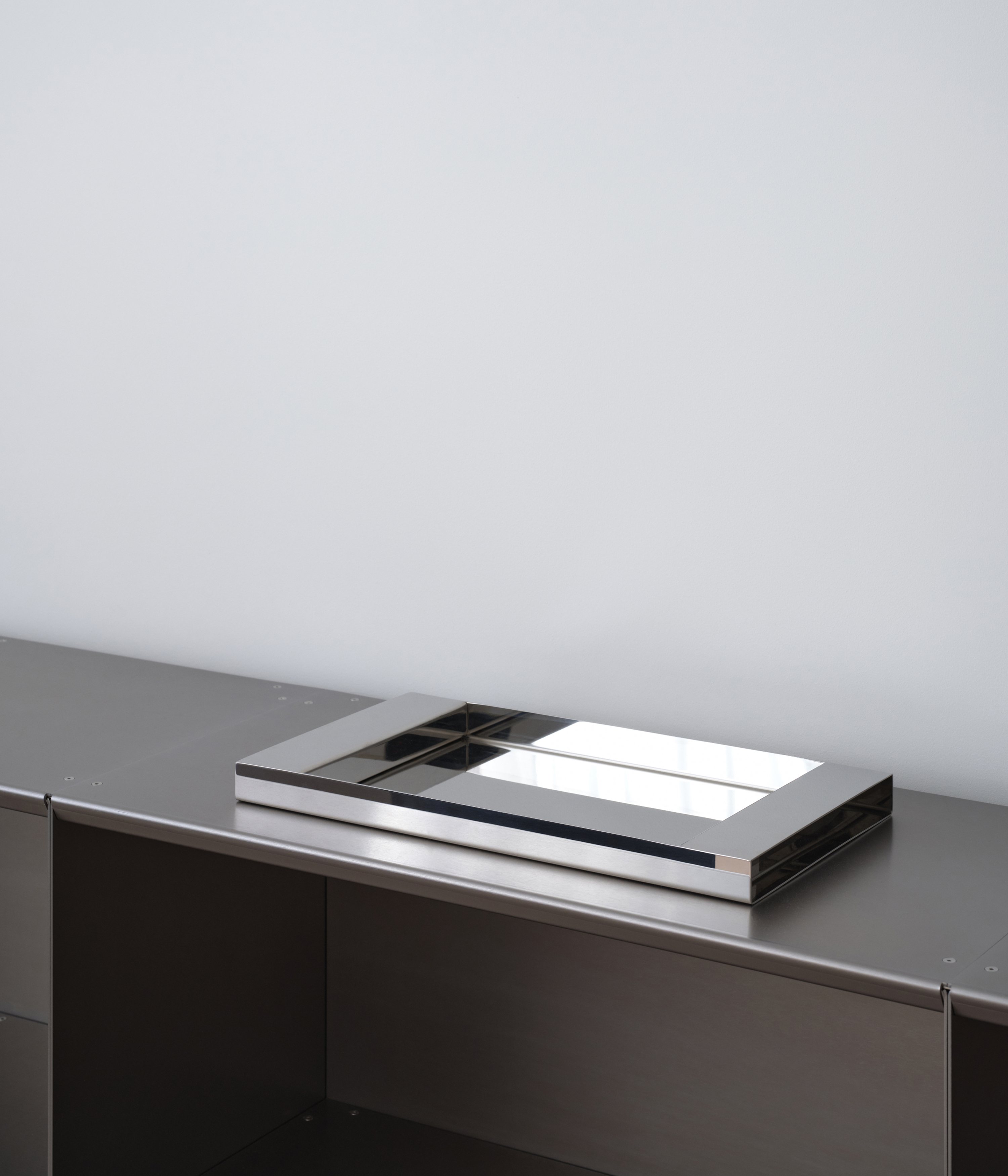 M85 stainless steel tray with mirror polish on M85 modular shelves and a grey background